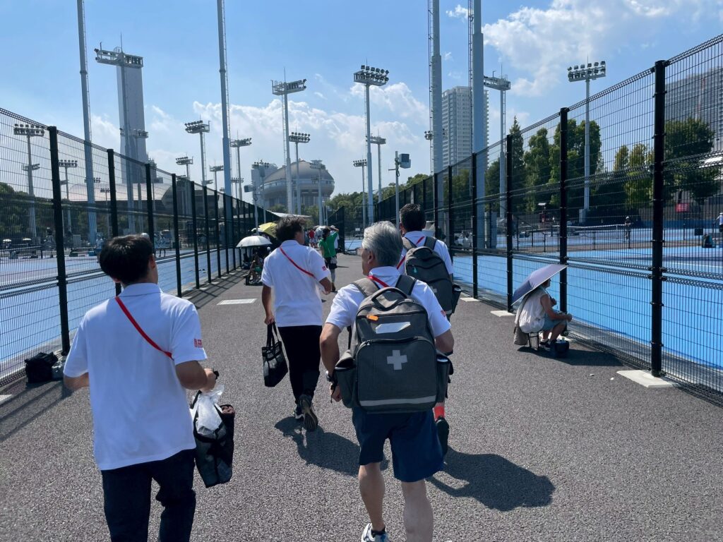 ユニクロ全日本ジュニアテニス選手権2025(有明)でのスポーツトレーナー活動記録。救急救護、熱中症の救急搬送対応、WBGTに基づくヒートルール運用、ドクター連携、トレーナールームのケアとコンディショニングを、確かなガイドラインに沿って分かりやすくレポート。春日部・埼玉でのサポートもご相談ください。